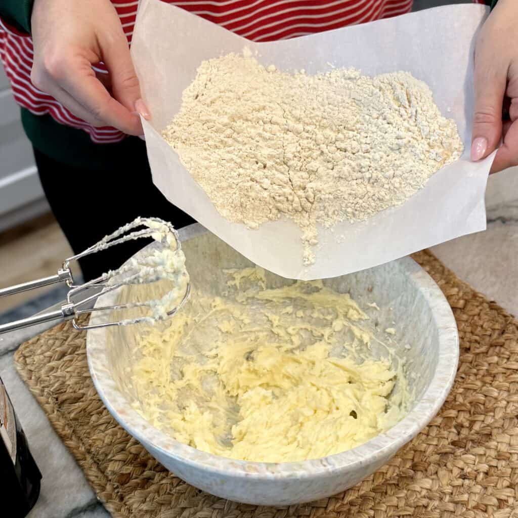 Adding flour to the bowl.