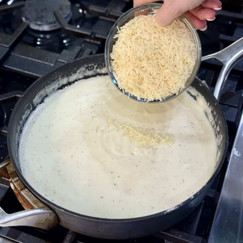 Adding cheese to the pan.