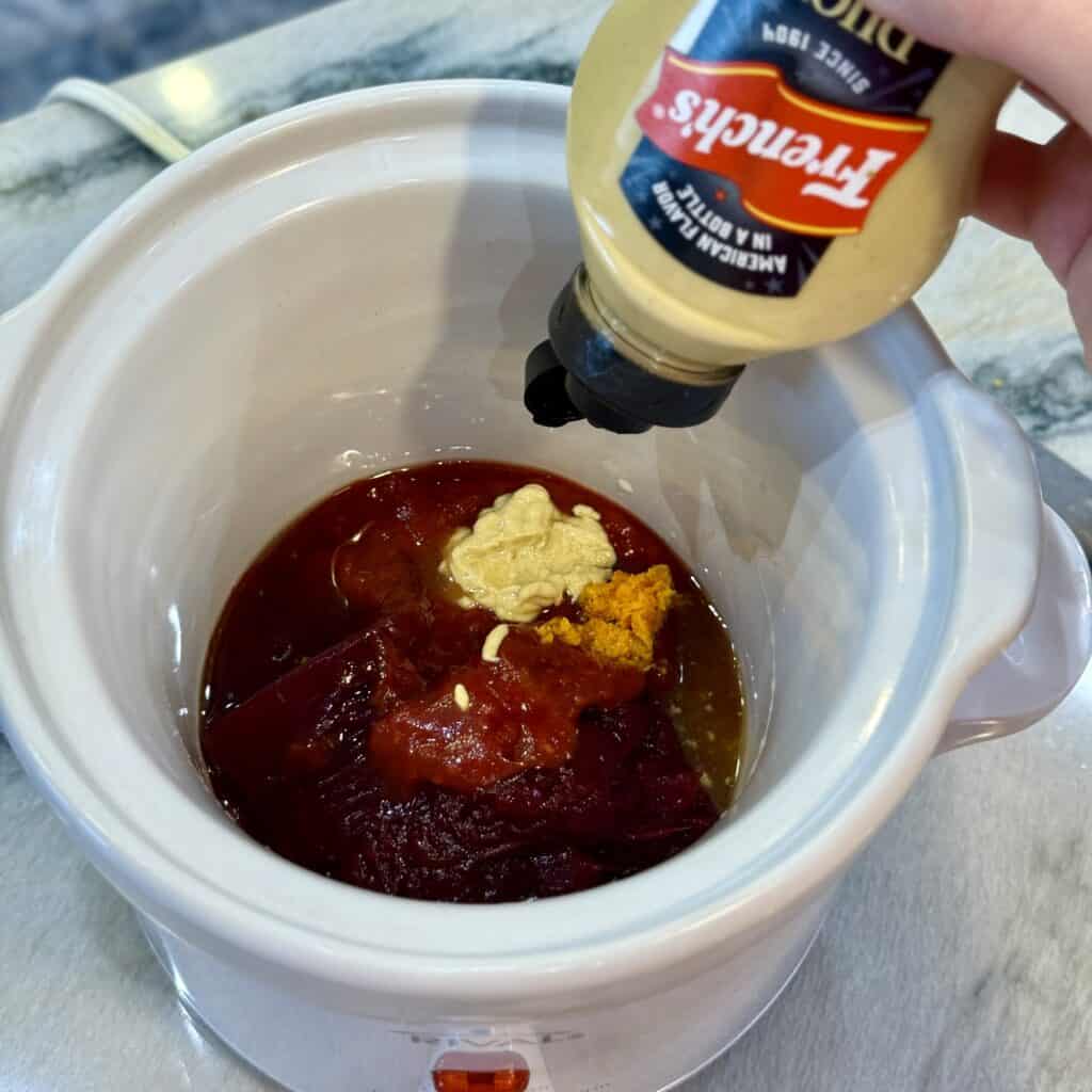 Adding mustard to the sauce mixture.