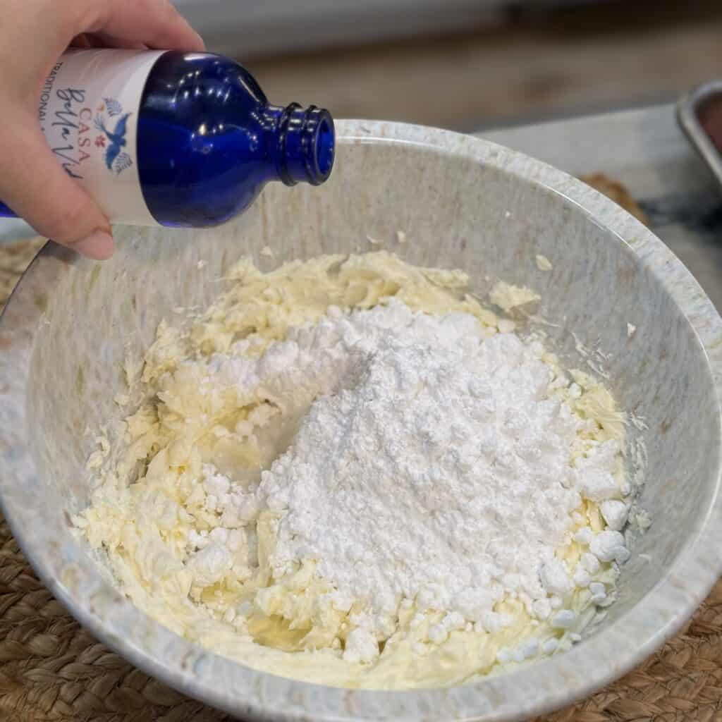 Adding vanilla extract to the bowl.