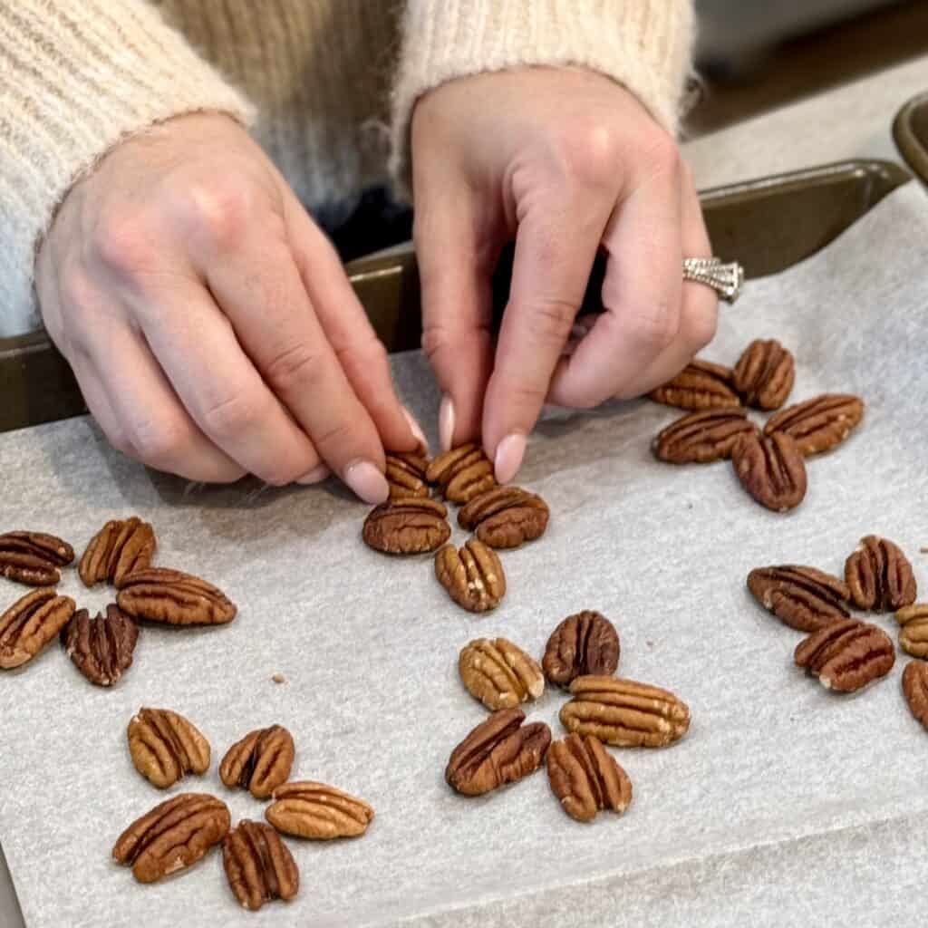 Placing the pecans into turtle shapes.
