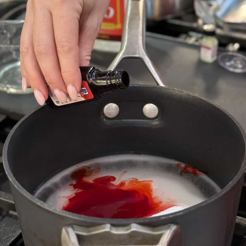 Adding food coloring to the pan.