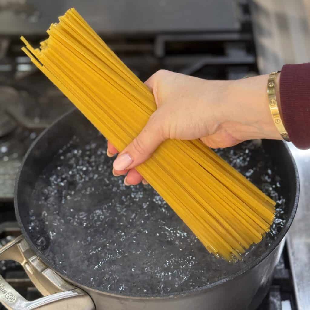 Adding pasta into the boiling water.