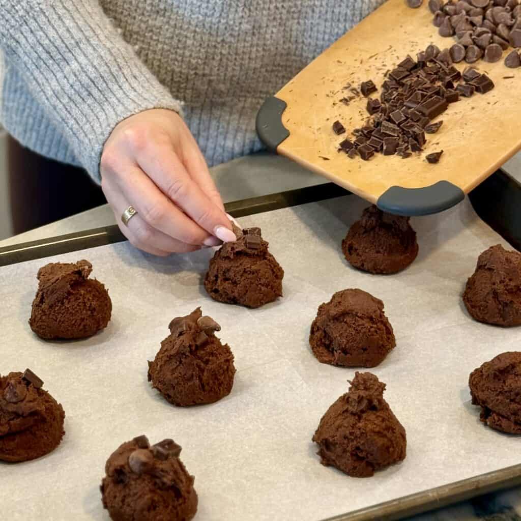 Adding chocolate on top of the cookies.