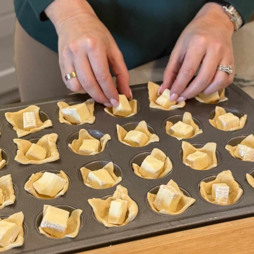 Adding cheese to dough bites.