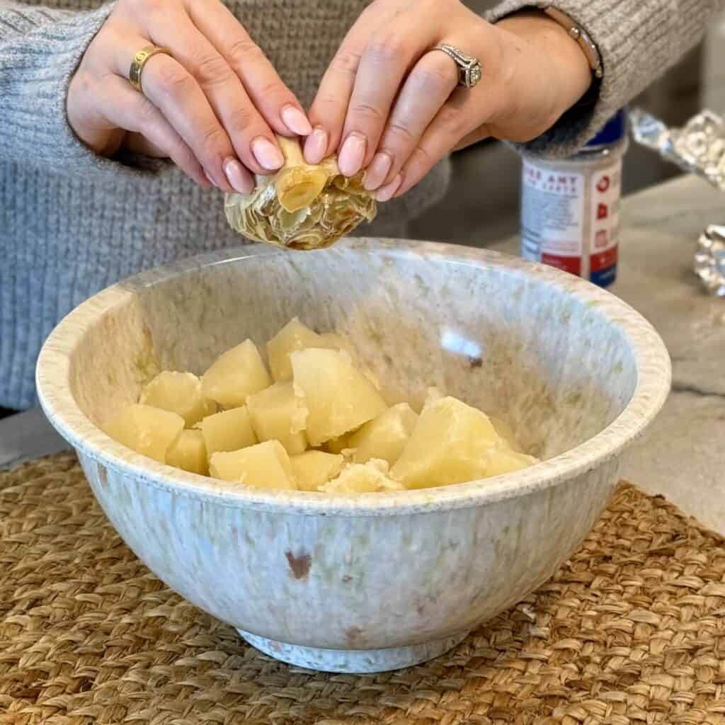 Adding garlic to the boiled potatoes.