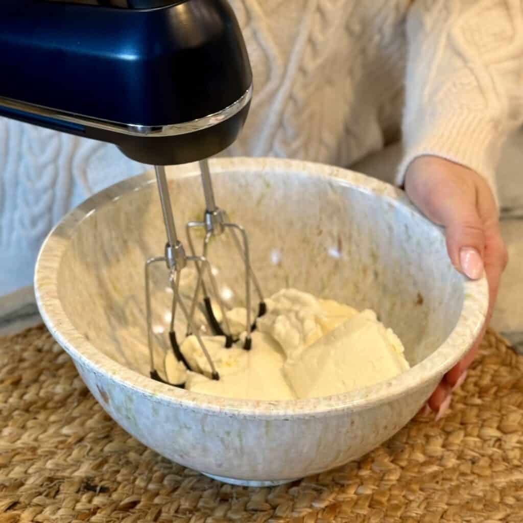 Whipping the cream cheese.