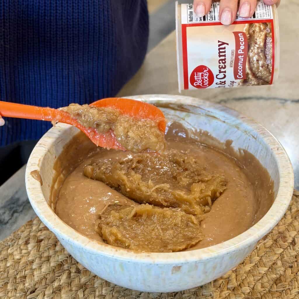 Adding pecan icing to the bowl.