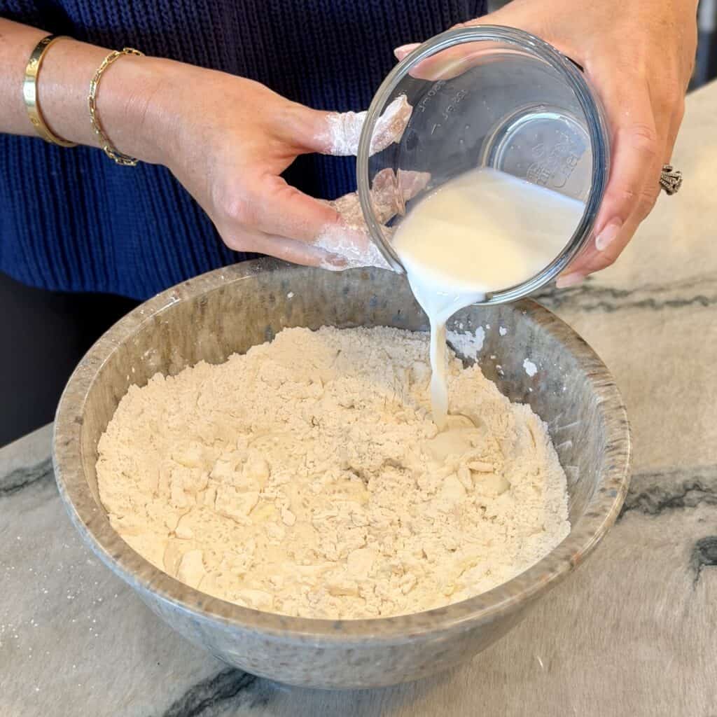 Adding milk to the dry ingredient bowl.