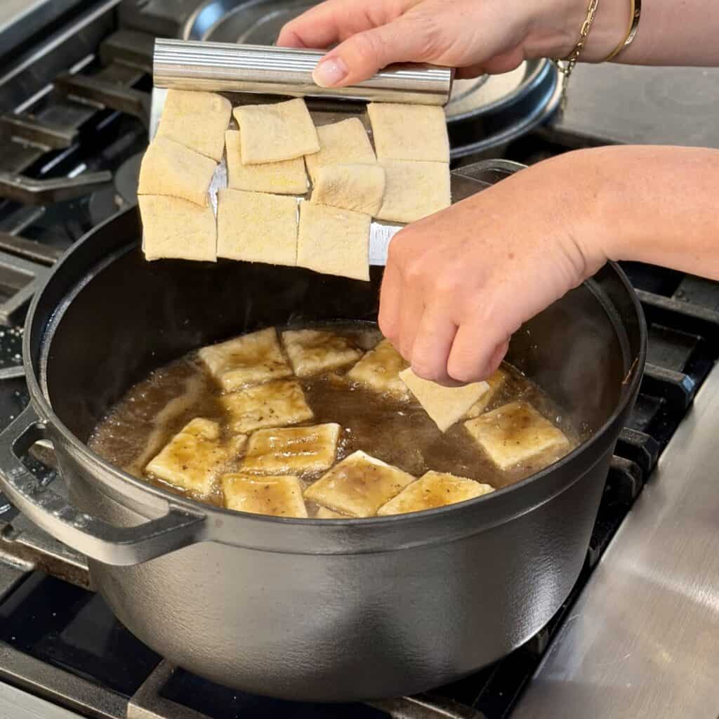 Adding the dough into the pot.