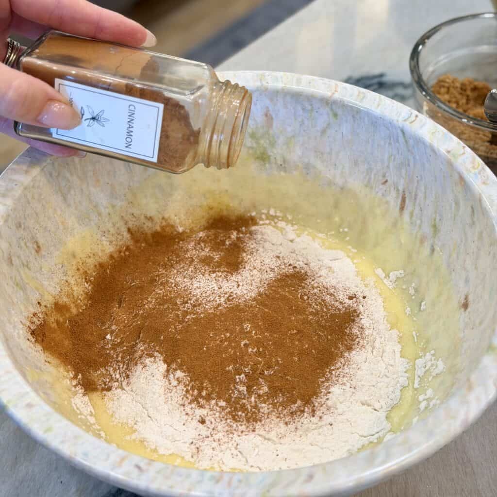Adding cinnamon to the bowl.