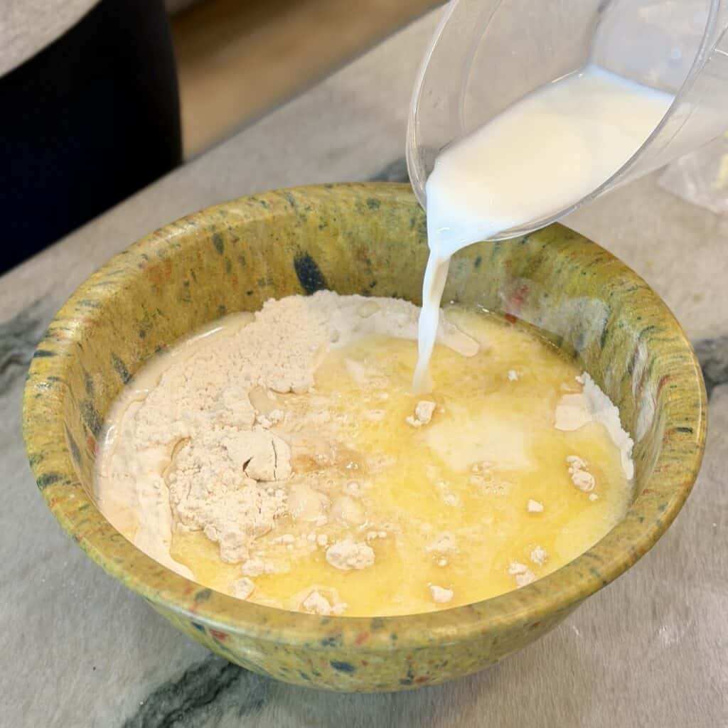 Adding milk to the bowl.