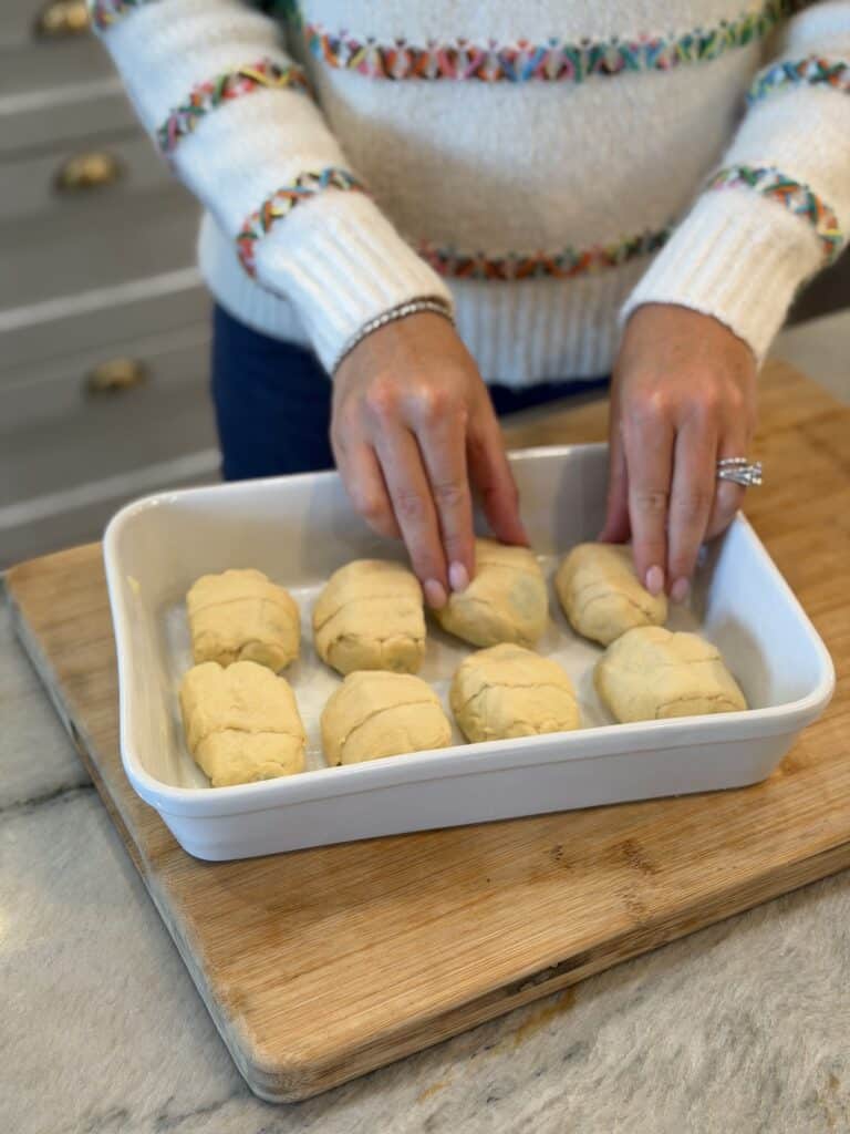 Adding apple dumplings to the pan.